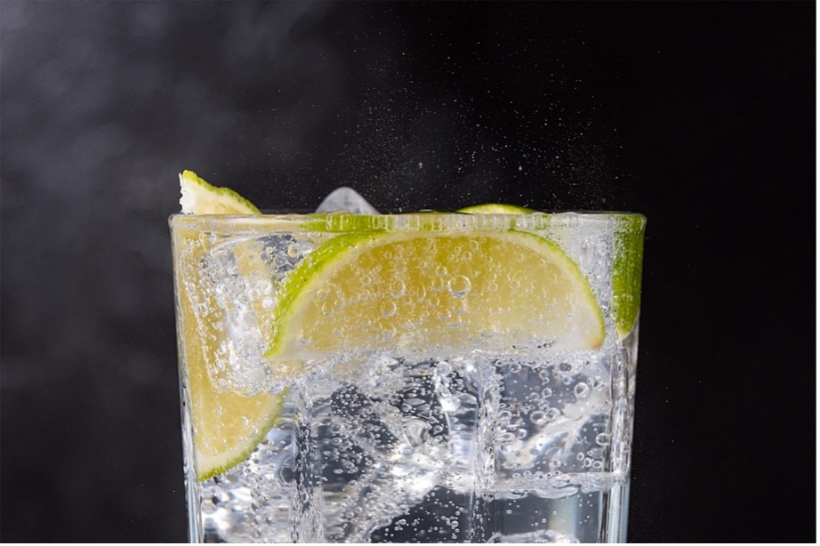 A glass of water with ice and lime slices