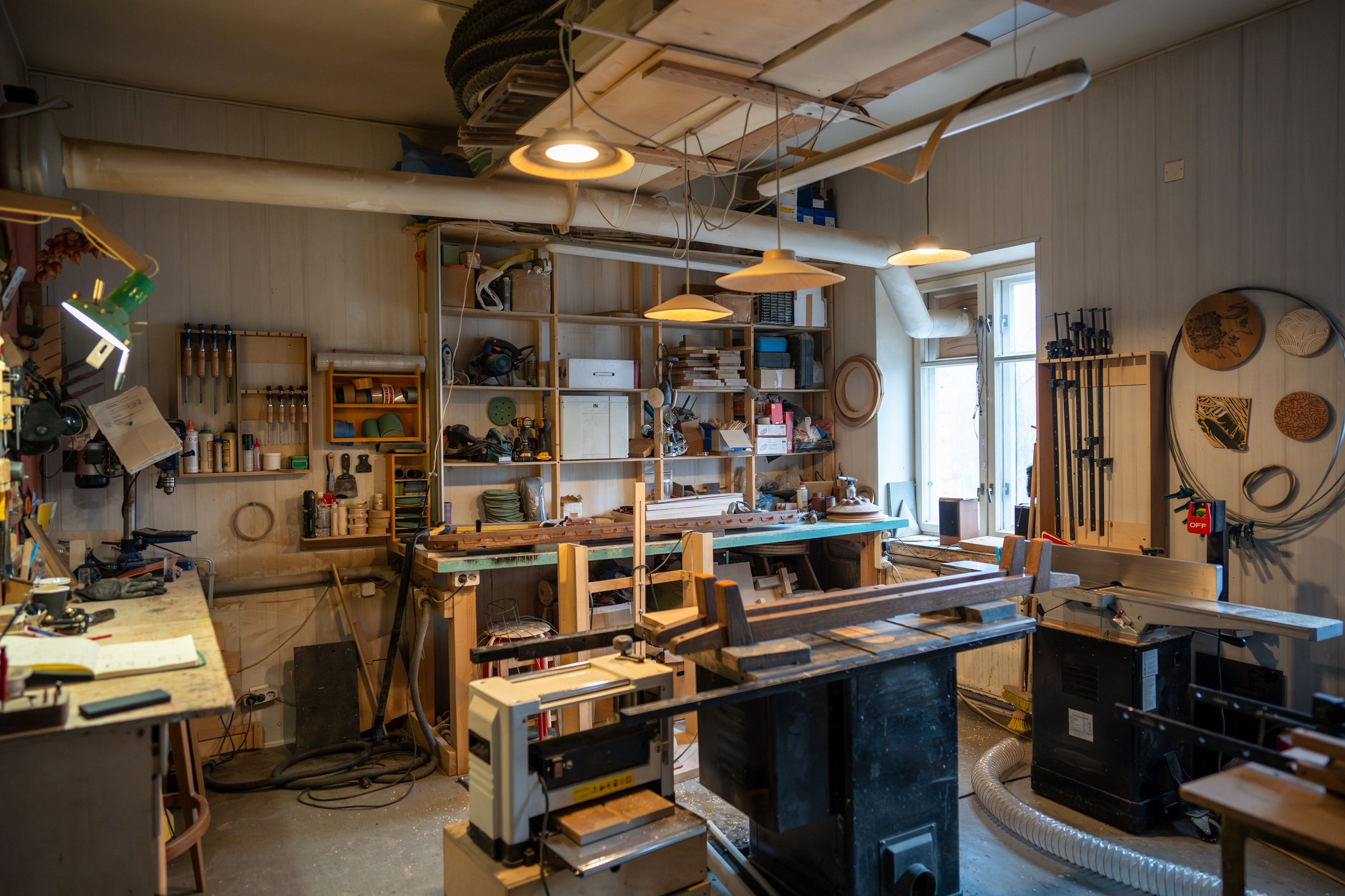 Organized tidy carpenter workplace for working with wooden products, making, creating furniture. Neat place for craftsman artisan to work with necessary accessories, tools, supplies, machines.